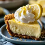 A slice of creamy lemon pie topped with whipped cream and lemon zest