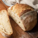 Freshly baked Dutch Oven Sourdough Bread on a wooden table