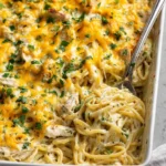 A bowl of easy chicken tetrazzini topped with parsley and melted cheese