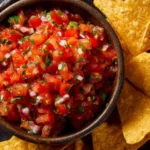 Bowl of vibrant garden fresh salsa with tomatoes, onions, and cilantro