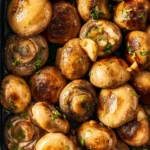 Sautéed garlic mushrooms in a skillet garnished with fresh herbs