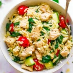 Plate of Greek lemon chicken served with orzo pasta and garnished with herbs