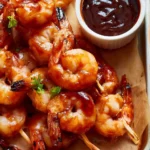 Grilled BBQ shrimp skewers with vibrant vegetables on a grilling grate