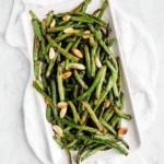 Grilled garlic green beans served on a plate, featuring vibrant colors and texture.