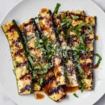 Grilled zucchini topped with Parmesan cheese, showcasing delicious summer flavors.