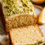 Sliced Lemon Pistachio Loaf garnished with lemon zest