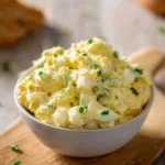 Delicious lighter egg salad served in a bowl with fresh herbs and vegetables