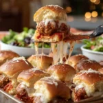 Delicious meatball sliders served on a rustic platter with sauce and garnish.