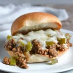 Philly Cheesesteak Sloppy Joes topped with cheese and served on a bun