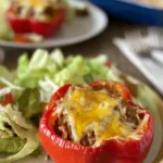 Taco stuffed peppers filled with ground beef, cheese, and fresh vegetables