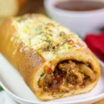 Cheesy BBQ steak stuffed garlic bread with melted cheese and herbs