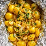 Delicious cheesy campfire potatoes cooking over a campfire