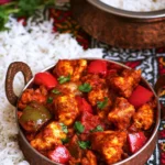Plate of Chicken Jalfrezi garnished with fresh herbs and served with rice