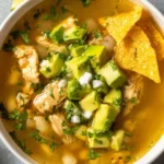 Bowl of Chicken Pozole Soup garnished with lime, radishes, and cilantro