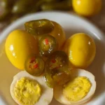 Cowboy Candy Pickled Eggs in a jar with spices for a tangy snack