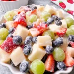 Creamy fruit salad with assorted fresh fruits in a bowl