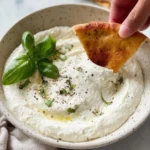 Creamy feta dip served with fresh vegetables and pita bread