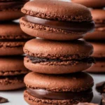 Foolproof chocolate macarons displayed on a plate with chocolate filling