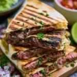 Grilled skirt steak quesadilla with melted cheese and fresh toppings