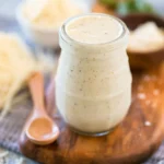 Creamy homemade Alfredo sauce served on pasta, garnished with parsley.