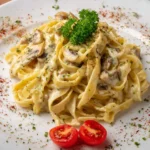 Bowl of homemade Alfredo sauce with pasta and herbs