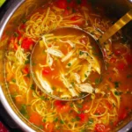 Bowl of Instant Pot Asian Chicken Noodle Soup with fresh herbs and noodles.