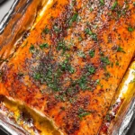 Delicious oven baked salmon fillet served with lemon and herbs.