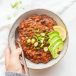 Bowl of Pumpkin Black Bean Chili topped with cilantro and avocado