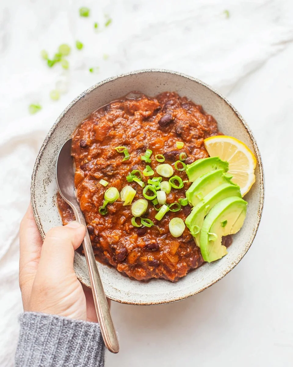Bowl of Pumpkin Black Bean Chili topped with cilantro and avocado