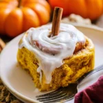 Freshly baked pumpkin cinnamon rolls with cream cheese frosting