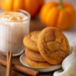 Freshly baked Pumpkin Snickerdoodles on a wooden table with spice sprinkles
