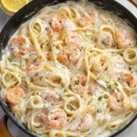 Delicious Shrimp Alfredo pasta topped with fresh herbs and shrimp
