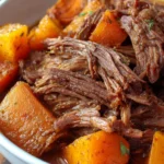 Tender and juicy slow cooker beef roast served with vegetables.