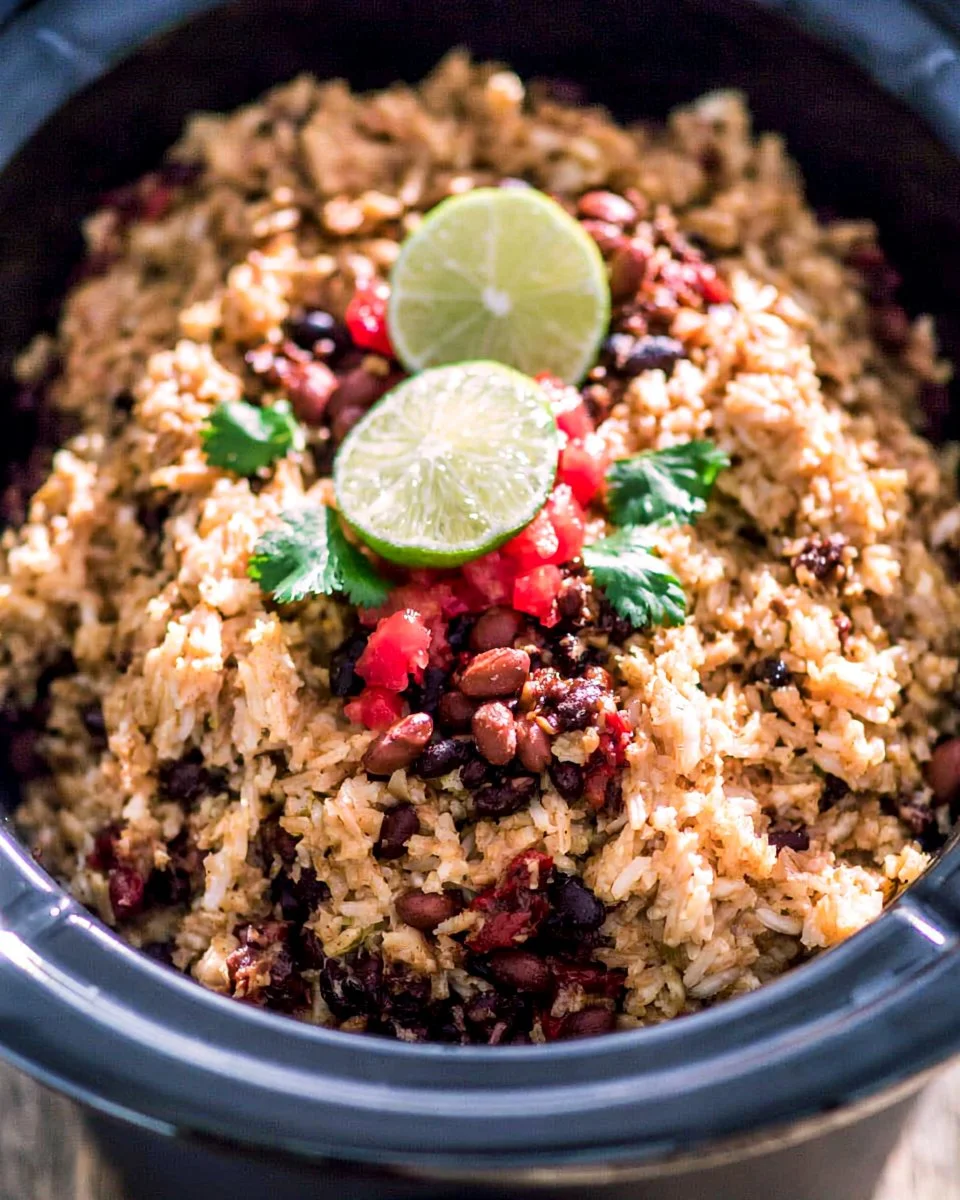 A bowl of Slow Cooker Rice and Beans served with fresh herbs and spices