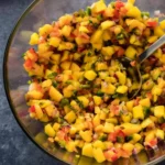 Bowl of spicy mango salsa with jalapeños served with tortilla chips