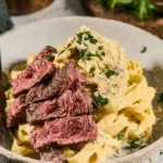Plate of Steak Alfredo featuring tender steak and creamy Alfredo sauce