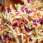 Fresh homemade coleslaw in a bowl with colorful vegetables