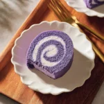 Delicious Ube Roll Cake with rich purple yam flavor, beautifully decorated.