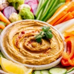Delicious Chipotle Hummus served with an array of colorful crunchy veggies.