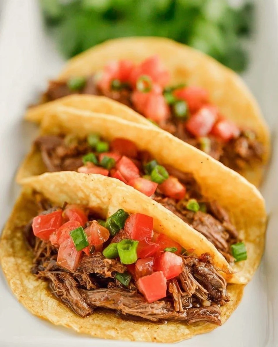 Slow cooker shredded beef tacos served with fresh toppings
