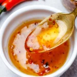 Homemade Sweet Chili Sauce in a glass bowl with fresh chili peppers
